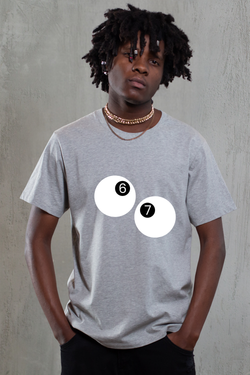 Person wearing a gray t-shirt with two white circles and numbers on a plain background