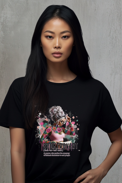 Model wearing a black t-shirt with a graphic design of a women reading a book and flowers on a gray background