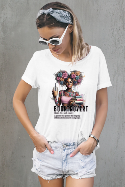 Woman wearing a white t-shirt with a graphic design and text, standing against a gray wall.