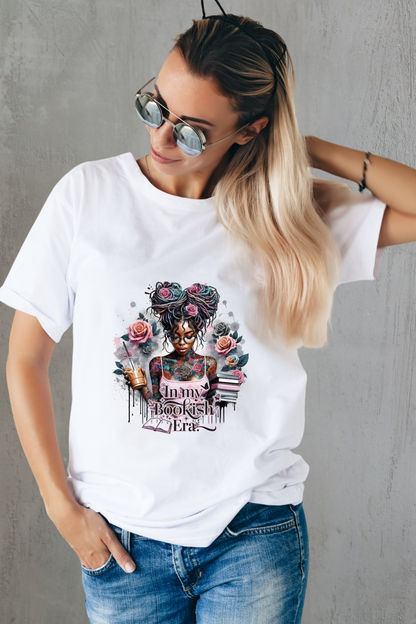 Woman wearing a white t-shirt with a graphic design and text, standing against a gray wall.