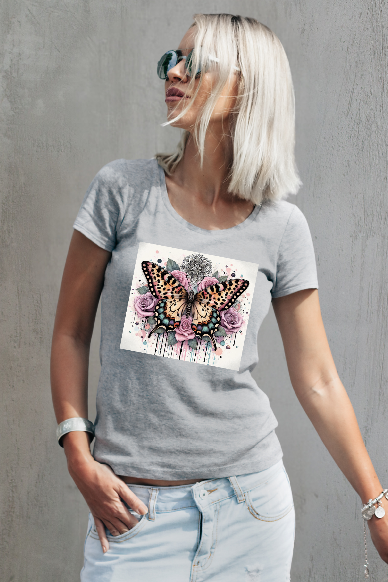 Woman wearing a gray t-shirt with a butterfly and flower design against a gray background