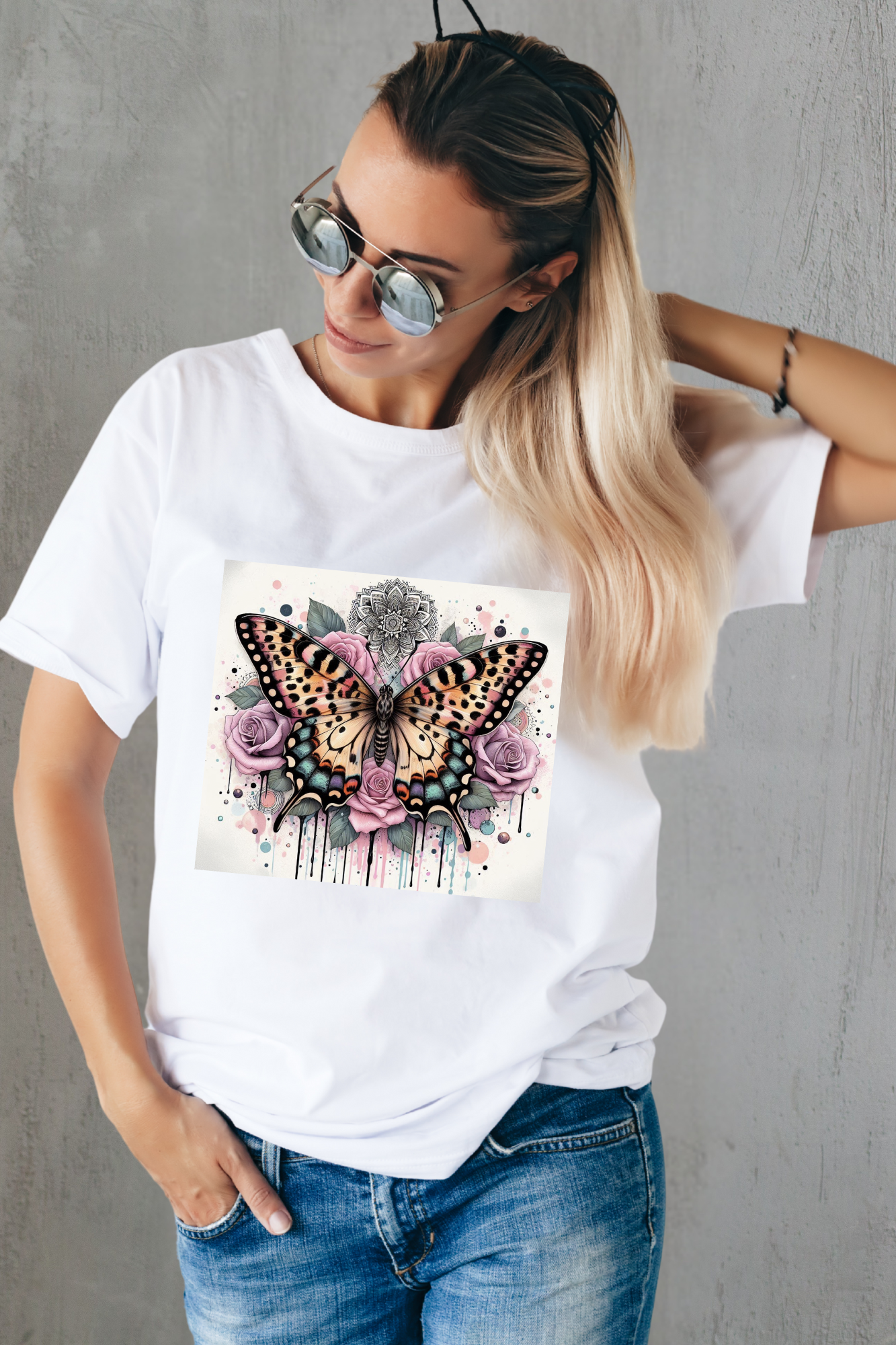Woman wearing a white t-shirt with a butterfly and floral design against a gray background