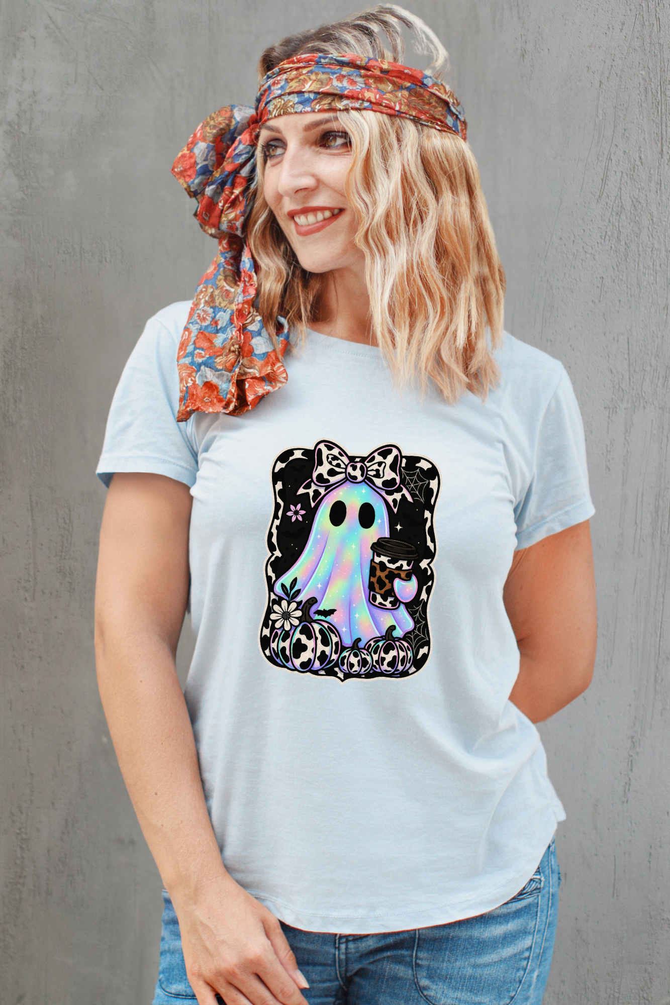 Woman wearing a light blue t-shirt with a colorful graphic design against a gray background