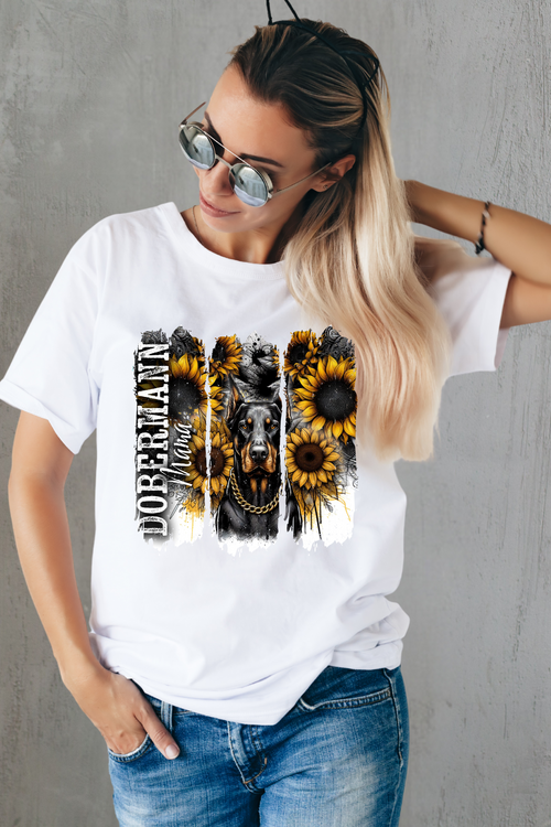 Regal Dobermann Mama T-shirt featuring fierce Dobermann with gold chain surrounded by sunflowers and grunge background, perfect for proud dog moms.