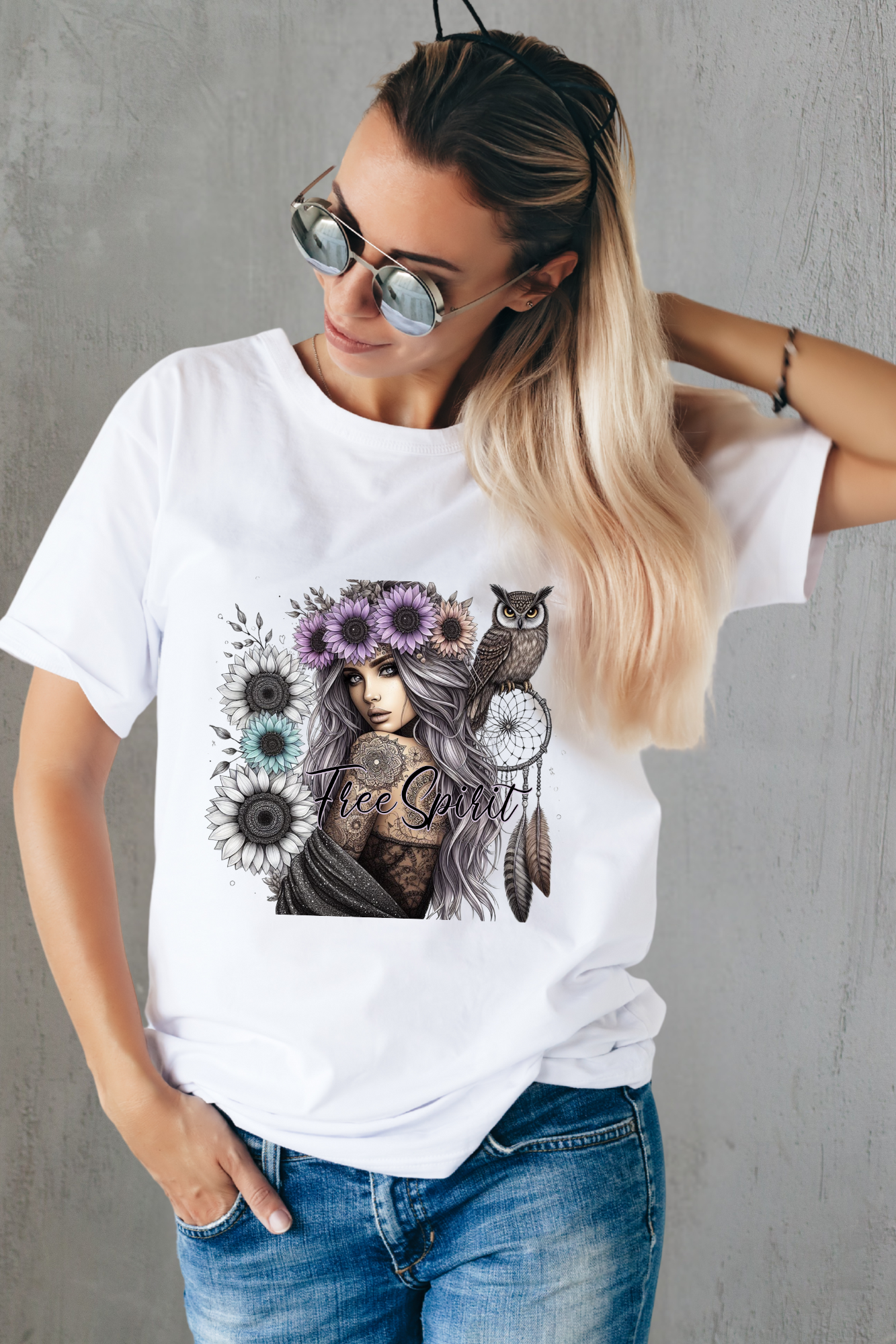 Woman wearing a white t-shirt with a graphic design of a woman with tattoos, flowers, and owls.