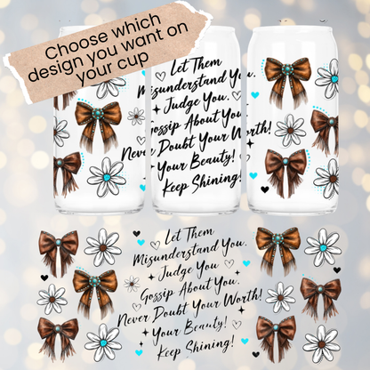 Three clear cups with decorative bows and flowers on a light gray background.