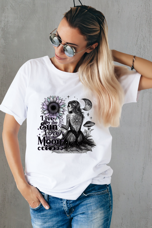 Woman wearing a white t-shirt with a graphic design and sunglasses, standing against a gray wall.