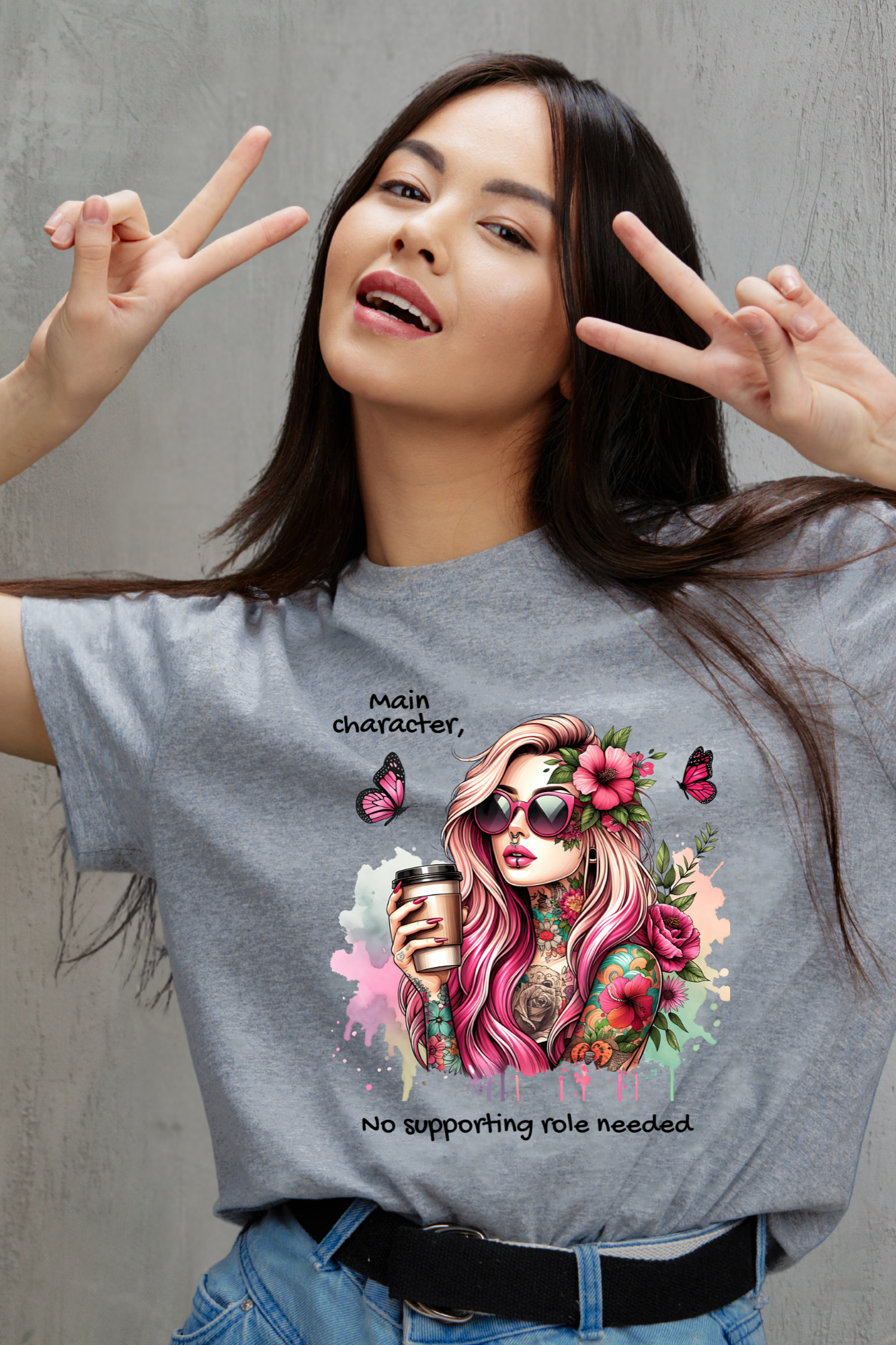 Woman wearing a t-shirt with a colorful graphic design of a woman with flowers and butterflies, making peace signs.