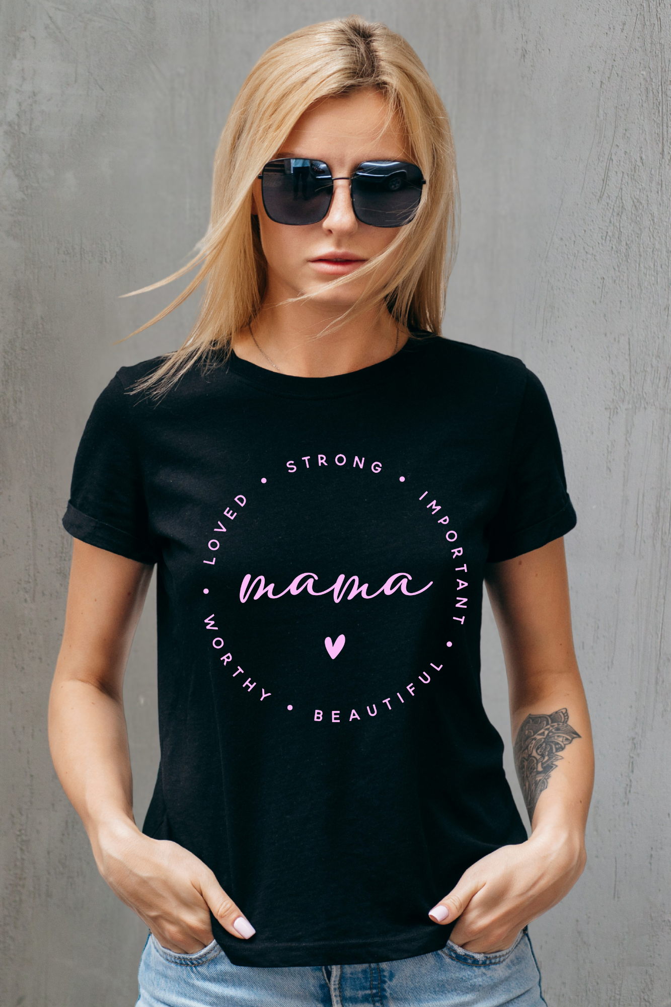 Woman wearing a black t-shirt with 'mama' text against a gray background