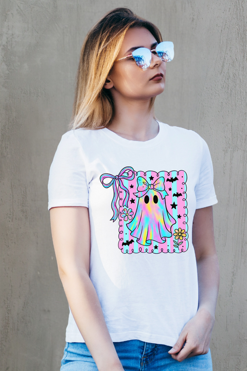 Person wearing a white t-shirt with a colorful graphic design against a gray background