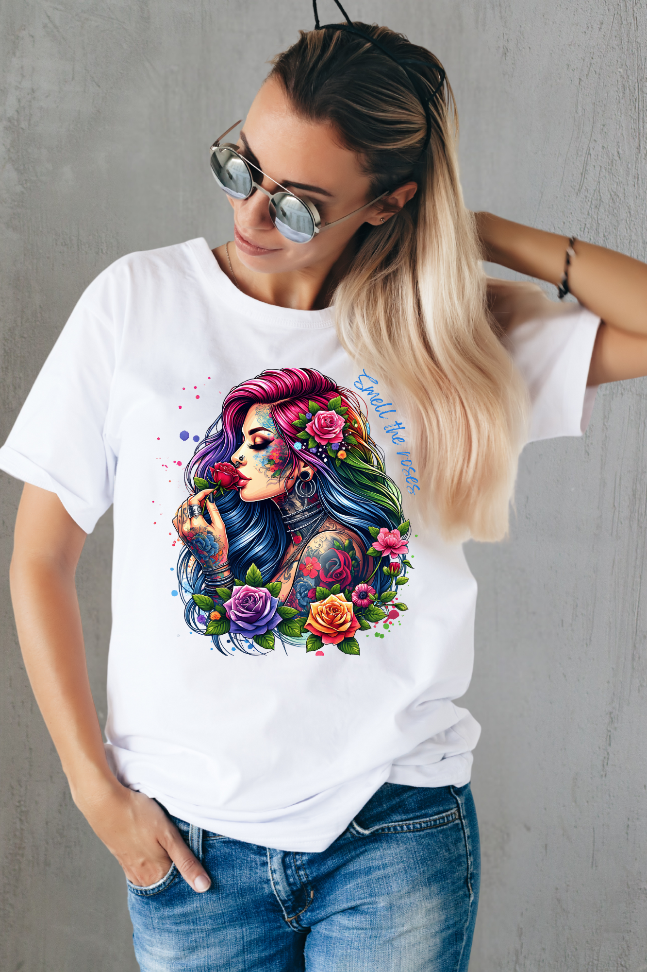 Woman wearing a white t-shirt with a colorful graphic design of a woman with tattoos and flowers.