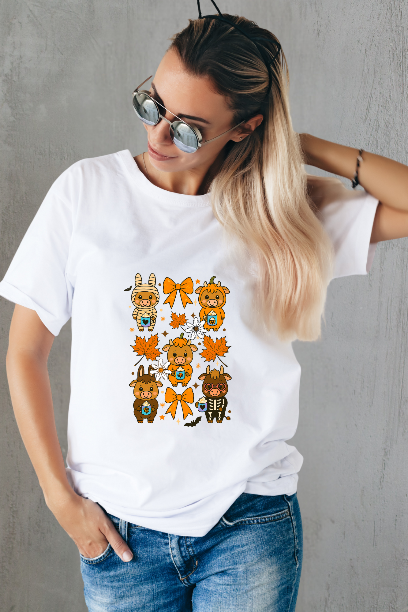 Woman wearing a white t-shirt with cartoon cow designs against a gray wall.