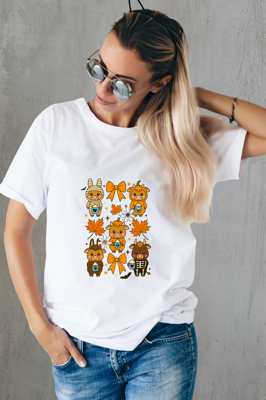 Woman wearing a white t-shirt with cartoon cow designs against a gray wall.