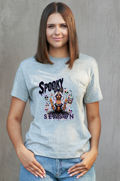 Woman wearing a grey t-shirt with a graphic design and text against a grey background