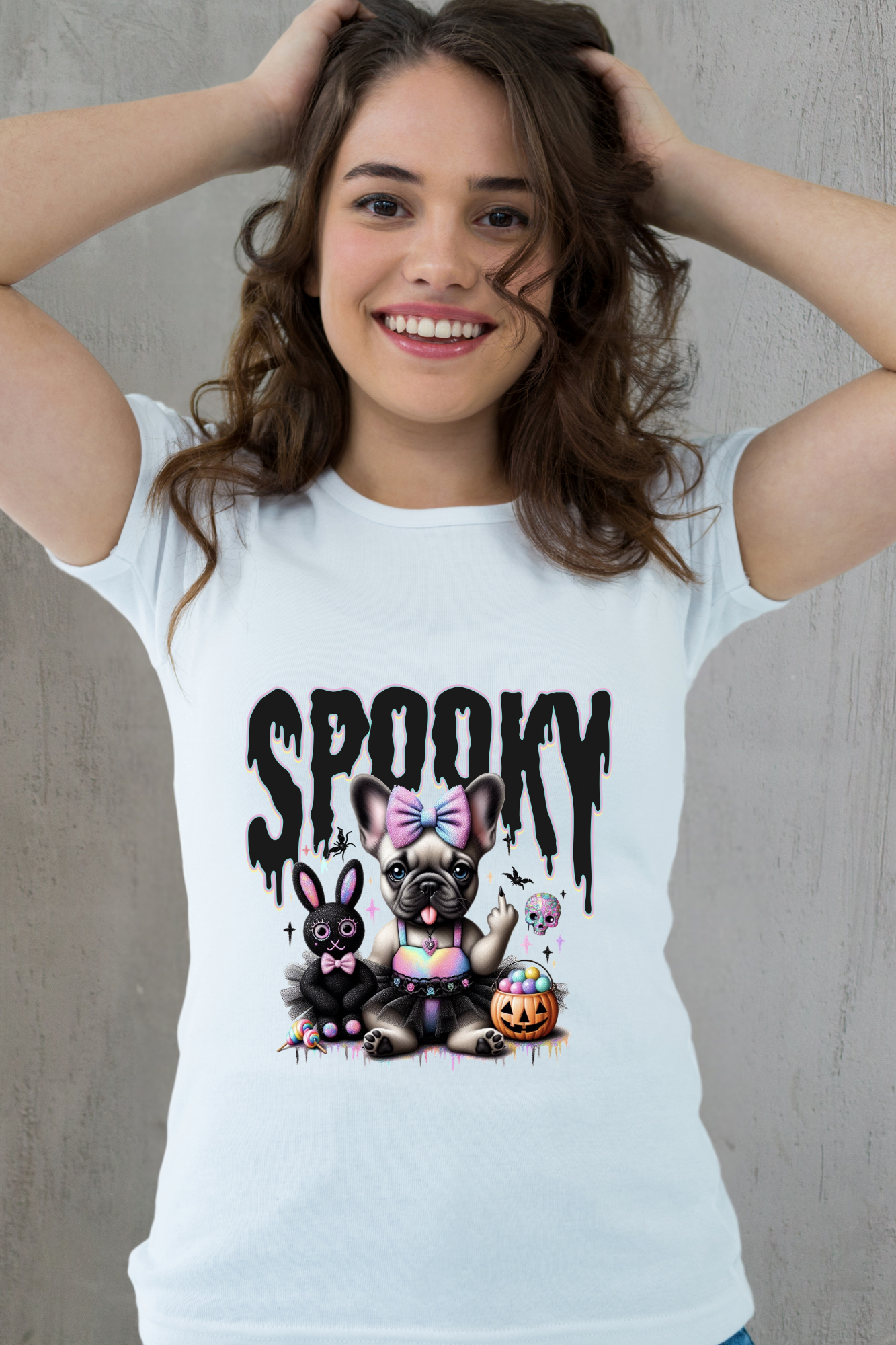 Woman wearing a white t-shirt with cartoon dogs and 'Spooky' text on a plain background
