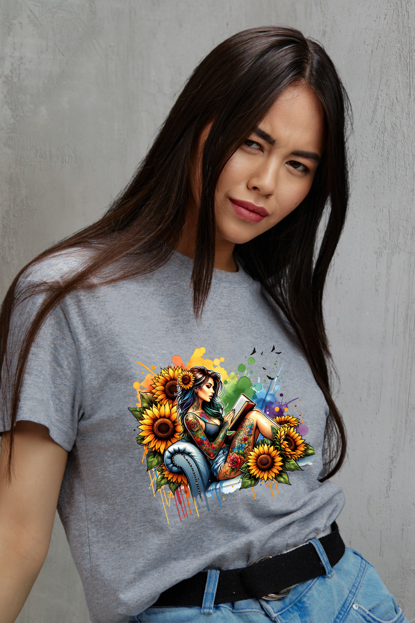 Woman wearing a gray t-shirt with a colorful graphic design of a woman surrounded by a bouquet of sunflowers.