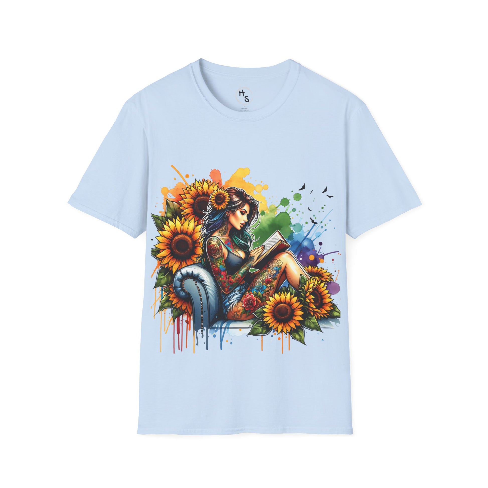 Light blue t-shirt with a colorful graphic of a woman reading a book surrounded by sunflowers on a light blue background.