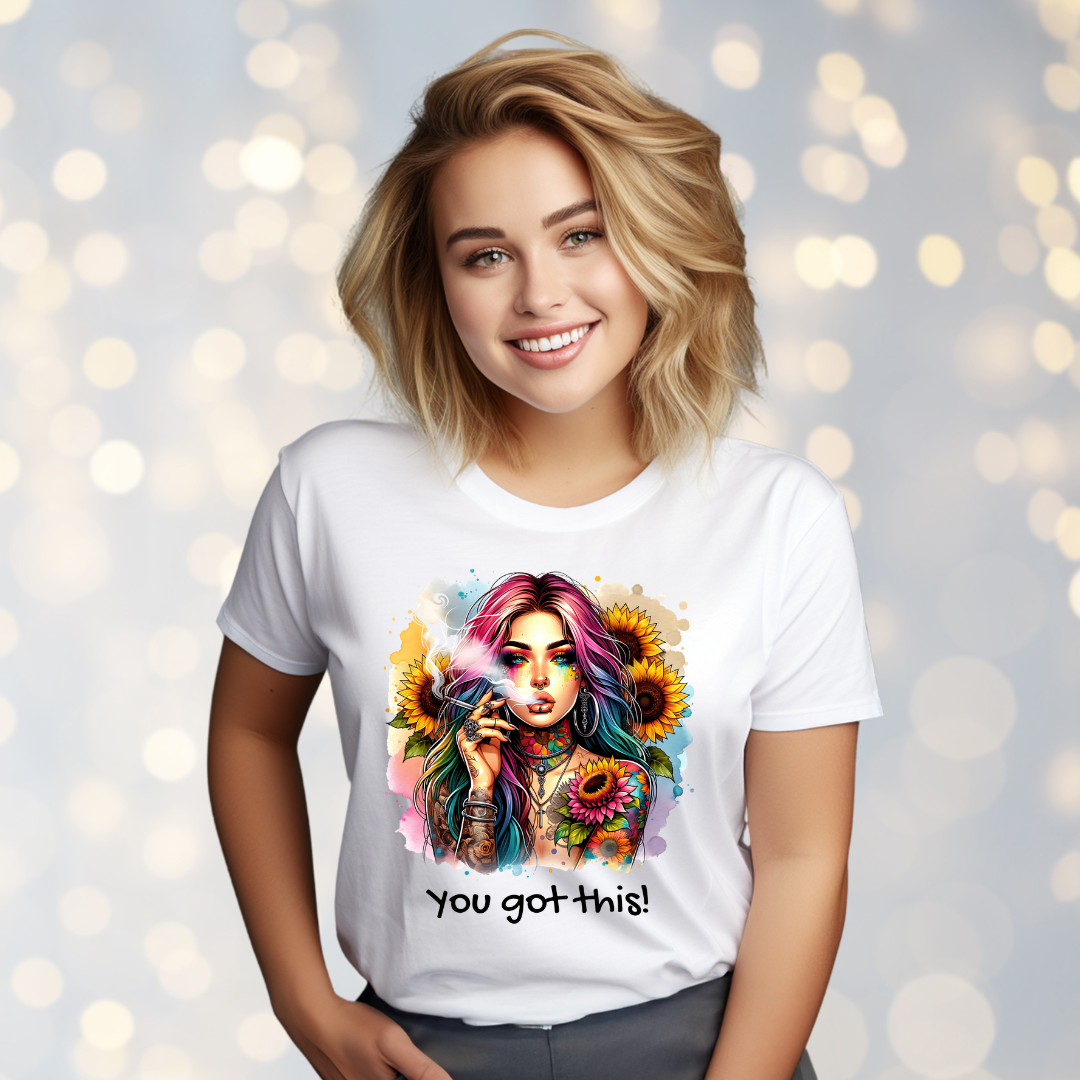 Woman wearing a white t-shirt with a colorful graphic and 'You got this!' text against a bokeh light background